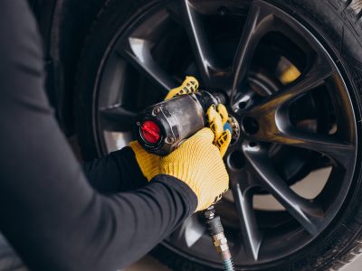 Car mechanic changing wheels in car